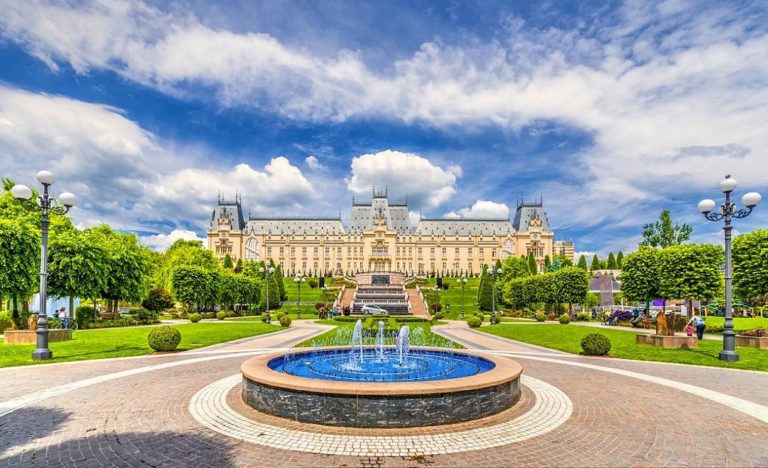 Palác kultury v Iasi s fontánou a upraveným parkem v popředí